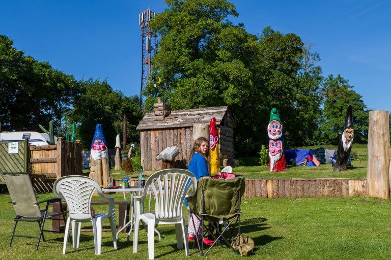 Tilshead grounds, with garden furniture and wooden cabin, Brades Acre Camping Site, Stonehenge, Wiltshire, Salisbury, camping, holiday lodges