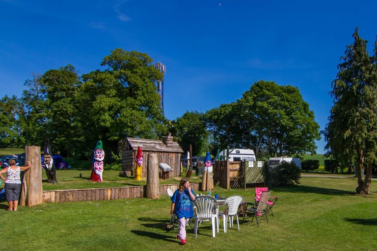 Tilshead grounds, with garden furniture and wooden cabin, Brades Acre Camping Site, Stonehenge, Wiltshire, Salisbury, camping, holiday lodges